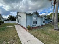 Charming single-story home featuring a well-maintained lawn and inviting walkway at 2004 Avon Blvd, Kissimmee, FL 34741