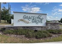 Gracelyn Grove community entrance sign with stone accents and well-maintained landscaping, under a bright blue sky at 2059 Dexter St, Haines City, FL 33844