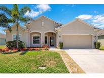 Charming single-story home featuring a well-manicured lawn, palm tree, and neutral-toned facade at 3894 Wind Dancer Cir, St Cloud, FL 34772