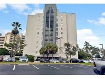 Exterior view of a towering condominium complex showcasing modern architecture and convenient parking at 6165 Carrier Dr # 1603, Orlando, FL 32819