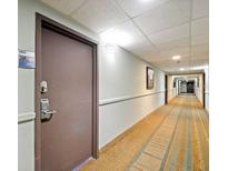 Hallway with neutral carpet, light walls, and the door of unit 1603 at 6165 Carrier Dr # 1603, Orlando, FL 32819