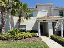 Inviting townhome exterior with tropical landscaping and a well-manicured lawn at 9055 Dogleg Dr, Davenport, FL 33896