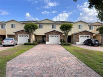 Charming townhomes with brick-paved driveways, stone accents, and lush landscaping under a sunny sky at 10116 Shadow Leaf Ct, Orlando, FL 32825