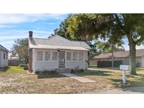 Charming cottage-style home featuring a new metal roof, brick chimney, and welcoming front porch at 1018 Jersey Ave, St Cloud, FL 34769