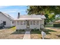 Charming single-story home with a metal roof, inviting front porch, and landscaped yard at 1018 Jersey Ave, St Cloud, FL 34769