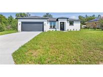 Well-maintained, modern home with a spacious front yard and attached garage at 2437 Sw 147Th Ln, Ocala, FL 34473