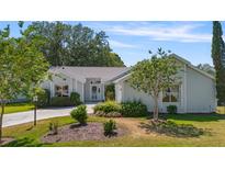 Charming single-story home featuring lush landscaping, a well-manicured lawn, and a welcoming entrance at 508 Alcazar Ct, The Villages, FL 32159