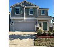 Charming two-story home with a two-car garage, green door, neutral colors and well-maintained landscaping at 804 Timberland Dr, Eagle Lake, FL 33839
