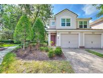 Charming townhome featuring a paved driveway, attached garage, manicured landscaping, and inviting curb appeal at 8374 Quimby Cir # 8374, Davenport, FL 33896
