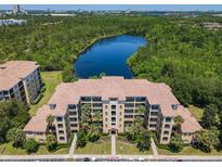 Aerial view of the condominium complex with a lake and lush surroundings at 8774 Worldquest Blvd # 7503, Orlando, FL 32821