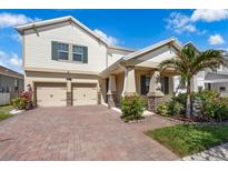 Charming two-story home featuring a paver driveway, attached two-car garage, and nicely landscaped front yard at 9056 Pinch Shot Dr, Winter Garden, FL 34787