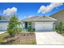 Charming single-Gathering home featuring a two-car garage and a well-manicured front yard at 1304 Berry Ln, Davenport, FL 33837