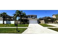 Well-maintained two story home featuring a manicured lawn and symmetrical landscaping for enhanced curb appeal at 14963 Braywood Trl, Orlando, FL 32824