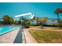 Community pool with lounge chairs surrounded by lush landscaping at 1695 Lee Rd # E215, Winter Park, FL 32789