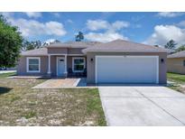 Charming single Gathering home featuring a two-car garage, neutral paint and manicured lawn at 199 Maple Dr, Kissimmee, FL 34759