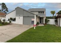 Charming two-story home with a well-maintained lawn and freshly painted gray trim at 2615 Autumn Green Dr, Orlando, FL 32822