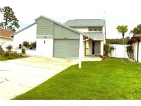 Charming two-story home with a well-maintained lawn and driveway at 2615 Autumn Green Dr, Orlando, FL 32822