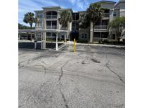 Exterior view of the condo building with a carport and palm trees at 3001 Laurel Run Ln # 101, Kissimmee, FL 34741