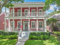 Inviting two-story home features a charming red exterior, double balconies, and a welcoming front porch at 715 Honeysuckle Ave, Celebration, FL 34747