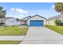 Charming single-story home with a well-manicured lawn and a blue garage door at 7830 Myrtle Oak Ln, Kissimmee, FL 34747