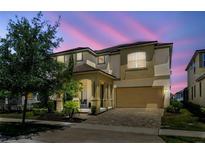 Elegant two-story home featuring a covered porch, attached garage, and well-maintained landscaping at 1817 Caribbean View Ter, Kissimmee, FL 34747