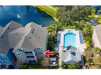 Aerial view of a lakeside condo community with a swimming pool and lush landscaping at 3344 Corona Village Way # 207, Orlando, FL 32835