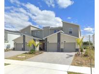 Contemporary townhomes featuring modern architectural design and attached garages at 637 Ocean Course Ave, Davenport, FL 33896