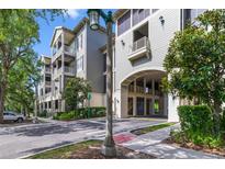 Beautiful condo building with a covered parking area entrance and mature landscaping at 650 Campus St # 309, Celebration, FL 34747