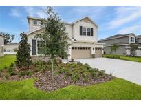 Two-story home featuring a three-car garage, stone accents, and freshly installed landscaping at 1019 Cloud Ridge Ct, Mount Dora, FL 32757