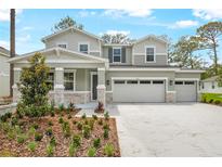 Charming two-story home with a three car garage, stone accents, and professionally landscaped front yard at 1067 Cloud Ridge Ct, Mount Dora, FL 32757