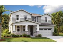 Charming two-story home features a stone and siding facade, complemented by well-manicured lawn and a two-car garage at 1067 Cloud Ridge Ct, Mount Dora, FL 32757