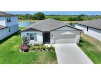 Charming single-Gathering home featuring a two-car garage, a well-manicured lawn, and fresh landscaping at 1158 Oak Valley Dr, Auburndale, FL 33823