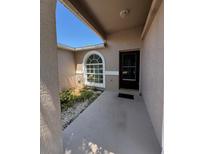 Inviting entryway with a decorative window and a well-maintained garden area at 2451 Quail Run N Blvd, Kissimmee, FL 34744