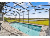 Sparkling pool with spa and screened enclosure overlooking the serene lake and community at 249 Bella Cortina Dr, Kissimmee, FL 34759