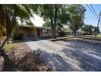 Charming single-story home with a driveway, mature trees, and red shutters for added curb appeal at 26 College Dr, Babson Park, FL 33827