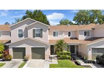 Inviting two-story townhouse with well-manicured landscaping, attached garages, and neutral stucco exterior at 3071 Seaview Castle Dr, Kissimmee, FL 34746