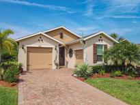 Charming single-Gathering home with a brick driveway, landscaped yard, and attached two-car garage at 105 Palazzo Ln, Kissimmee, FL 34759