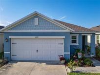 Charming single-story home featuring a 2-car garage, blue exterior, and beautifully landscaped front yard at 1379 Winter Gray Cir, Deltona, FL 32738