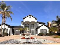Beautiful two story home featuring brick paved driveway, a front fountain and well manicured landscaping at 1407 Water Lilly Ln, Kissimmee, FL 34744