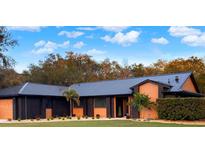 Stunning home featuring a dark metal roof and modern exterior paint scheme at 1849 Kings Point Blvd, Kissimmee, FL 34744