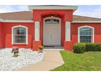 Inviting front entrance with white double doors, columns, and attractive landscaping at 318 Highland Meadows Dr, Davenport, FL 33837