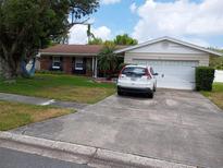 Charming single-story home featuring a well-manicured lawn and attached two-car garage at 3231 Lowndes Dr, Winter Park, FL 32792