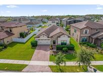 Aerial view of a single Gathering home in a well-maintained neighborhood with green lawns and a brick paver driveway at 3366 Puxton Dr, Orlando, FL 32824