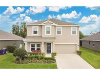 Beautiful two-story home featuring a well-manicured lawn, two-car garage, and neutral color palette at 3881 Wind Dancer Cir, St Cloud, FL 34772