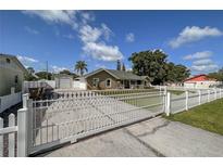 Charming home featuring a gated driveway, well-maintained lawn, and a detached garage at 5572 Myakka Ave, Intercession City, FL 33848
