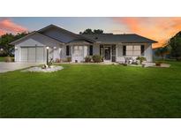 Charming single-story home with a well-manicured lawn and inviting front porch at 5919 Mcenroe Ct, Leesburg, FL 34748