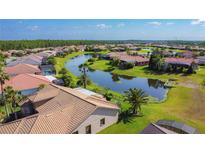 An aerial view of a residential community featuring lush landscaping and a scenic lake winding through the properties at 772 San Raphael St, Kissimmee, FL 34759