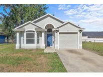 Charming single-story home with a well-manicured lawn, featuring a light gray facade and a blue front door at 108 Pearlwood St, Orlando, FL 32811