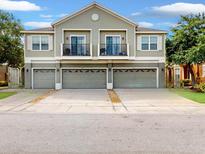 Charming townhome with multiple car garages and quaint balconies, enhancing curb appeal at 1933 Estancia Cir, Kissimmee, FL 34741