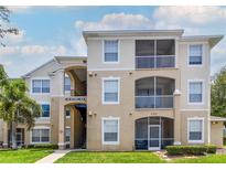 Inviting condominium featuring a charming exterior, balconies, and well-maintained landscaping at 2301 Butterfly Palm Way # 303, Kissimmee, FL 34747